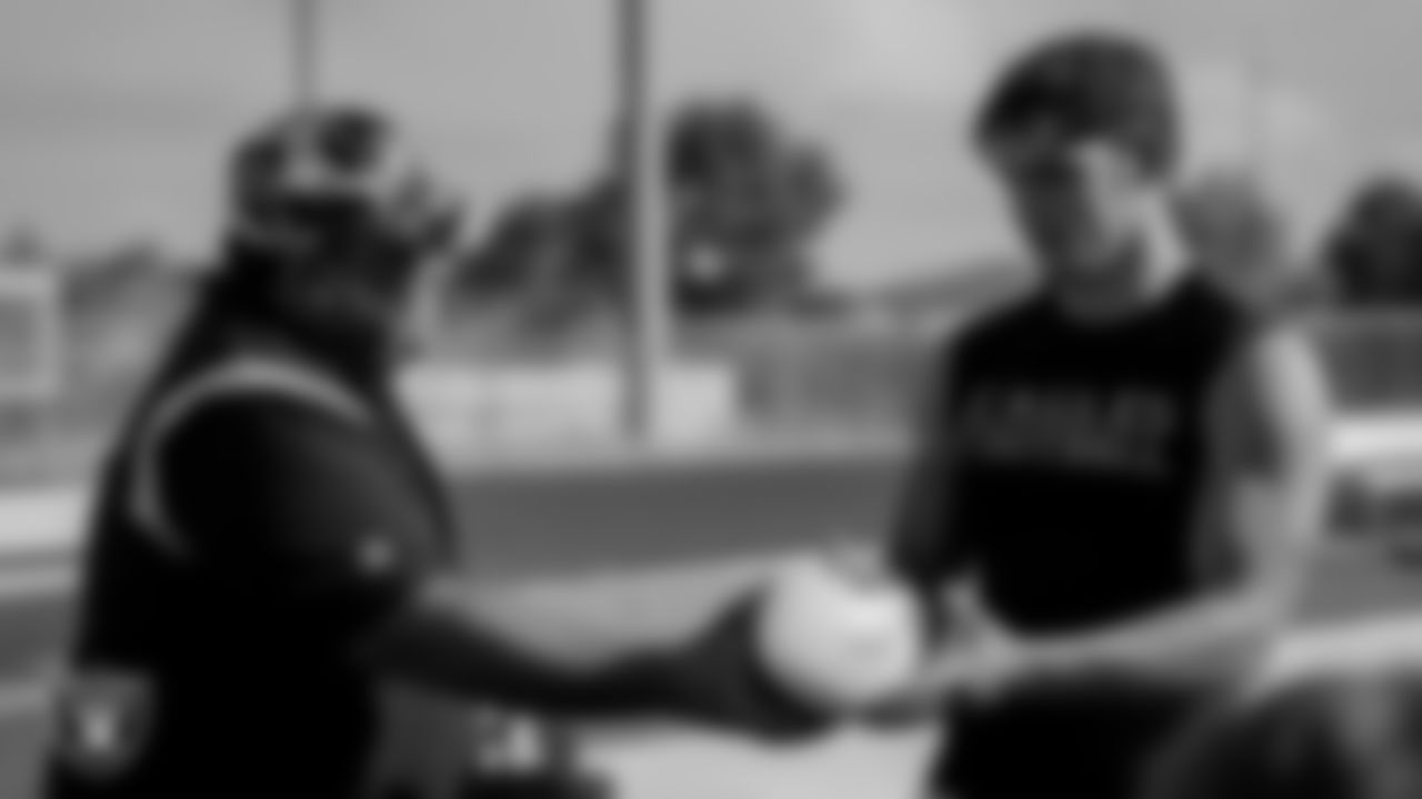 Las Vegas Raiders youth football manager Jordan Aguilar presents Boulder City High School's running back/linebacker Hunter M. with the Most Outstanding Performer football award.