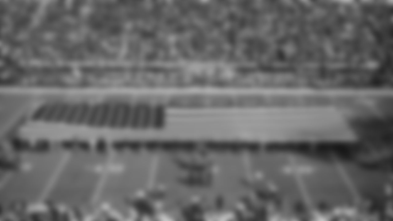 The American flag is displayed by members from the 91st Division of Army, 23rd Marine Regiment of the Marine Corps, Beale Air Force Base and U.S. Coast Guard Base Alameda on the field during the national anthem before the Raiders regular season game against the Cincinnati Bengals.