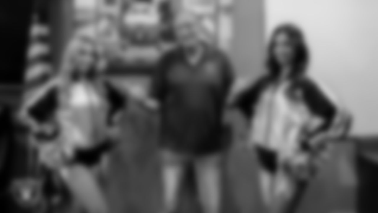 Raiderettes Lilah and Maddie take a photo with a first responder at Community Ambulance.