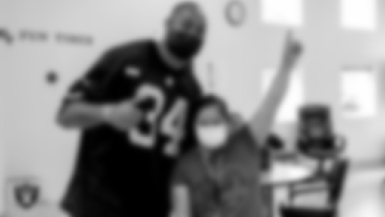 Las Vegas Raiders linebacker K.J. Wright (34) poses for a photo with an Opportunity Village participant.