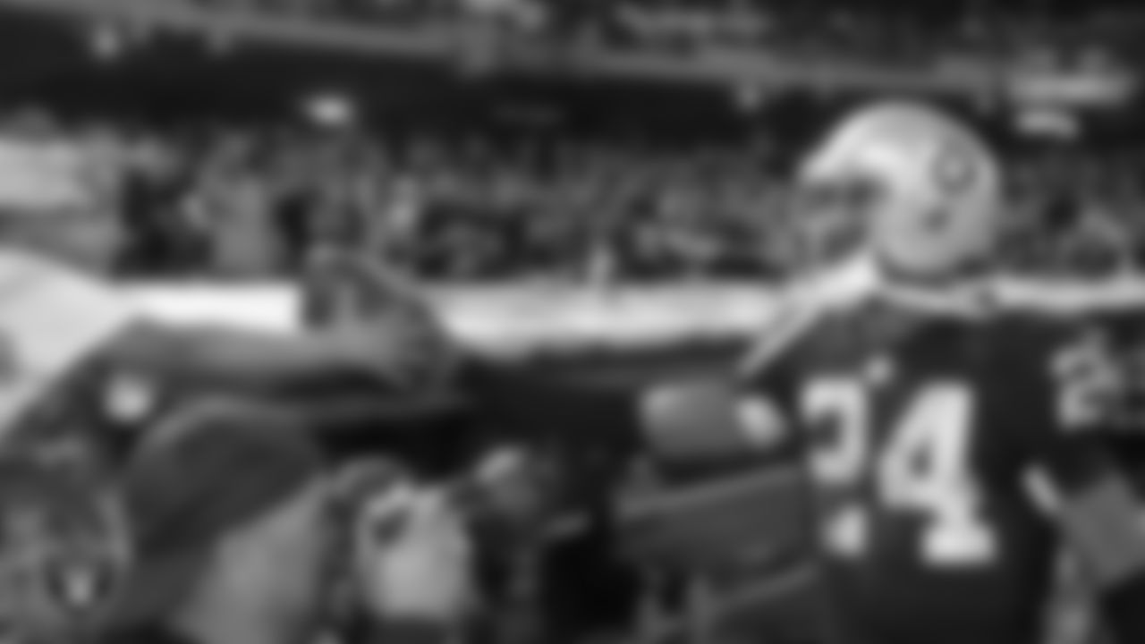 Raiders cornerback Charles Woodson (24) hands a football to a fan after the regular season home game against the San Diego Chargers.