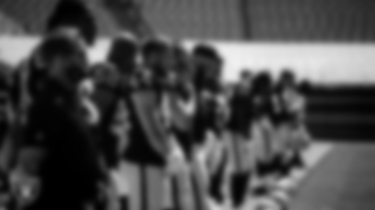 The Las Vegas Raiders stand on the sideline as a recording of "Lift Every Voice and Sing" is played before the regular season away game against the Carolina Panthers.