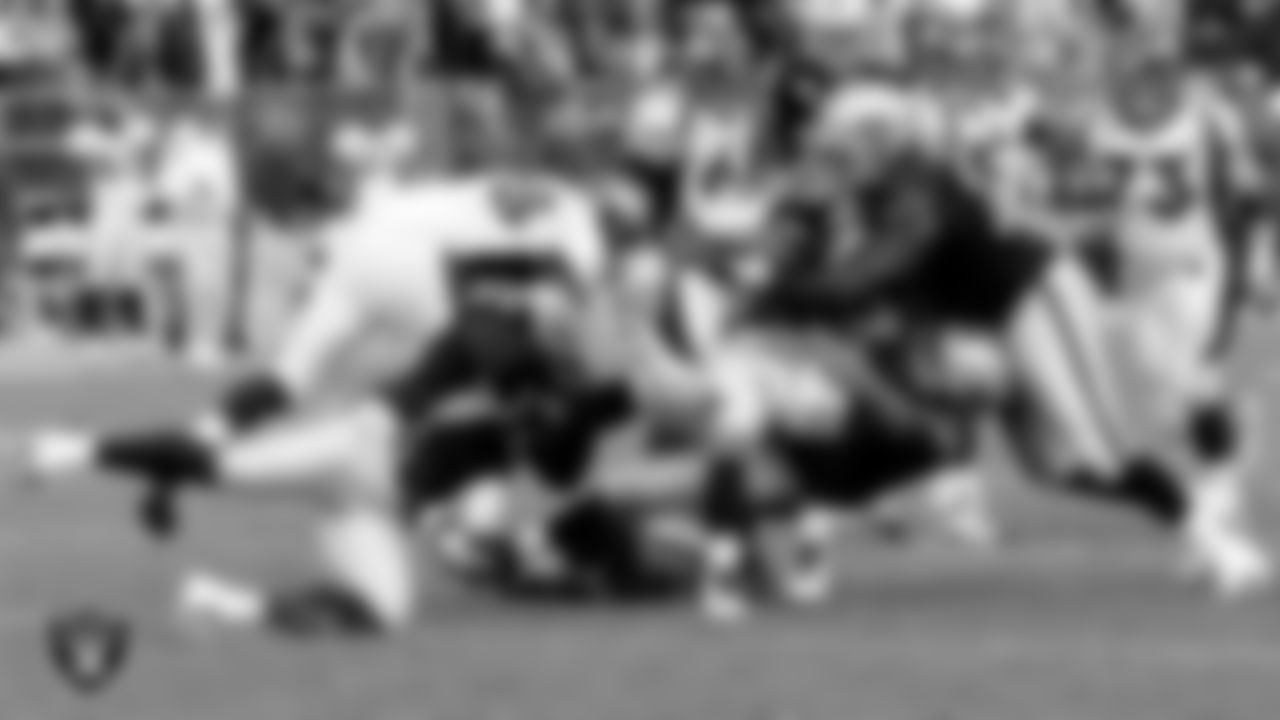 Raiders Tommy Kelly (93), Desmond Bryant (90) and John Henderson (79) make a tackle during the regular season home game against the Denver Broncos at O.co Coliseum, Sunday, November 6, 2011, in Oakland, Calif.