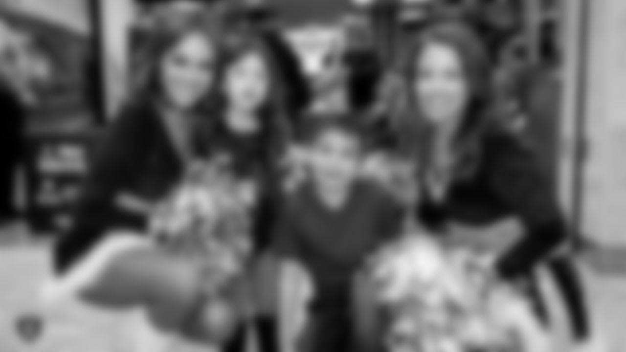 Raiderettes Mackenzie and Jen pose for a photo with young fans during the Raiders Foundation's Toys for Tots drive.