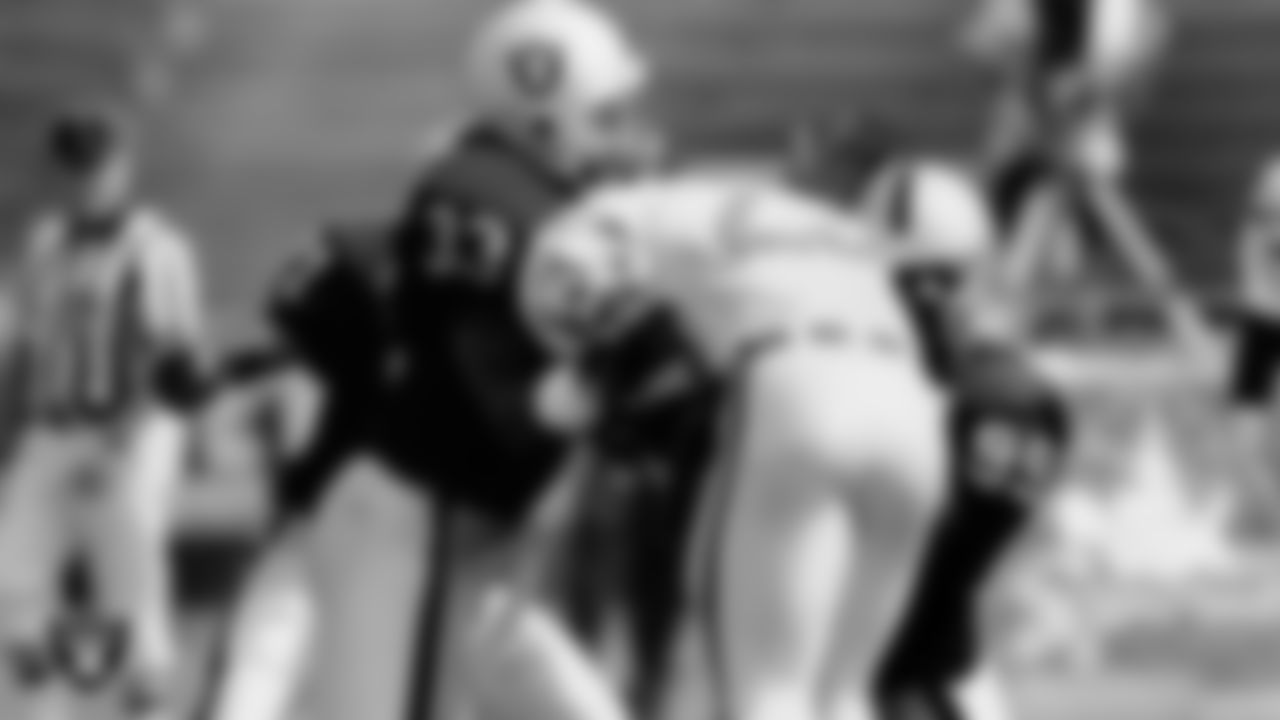 Raiders defensive back Eddie Anderson (33) and linebacker Winston Moss (99) make a tackle during the regular season home game against the Indianapolis Colts at Los Angeles Memorial Coliseum, Sunday, September 15, 1991, in Los Angeles, Calif.