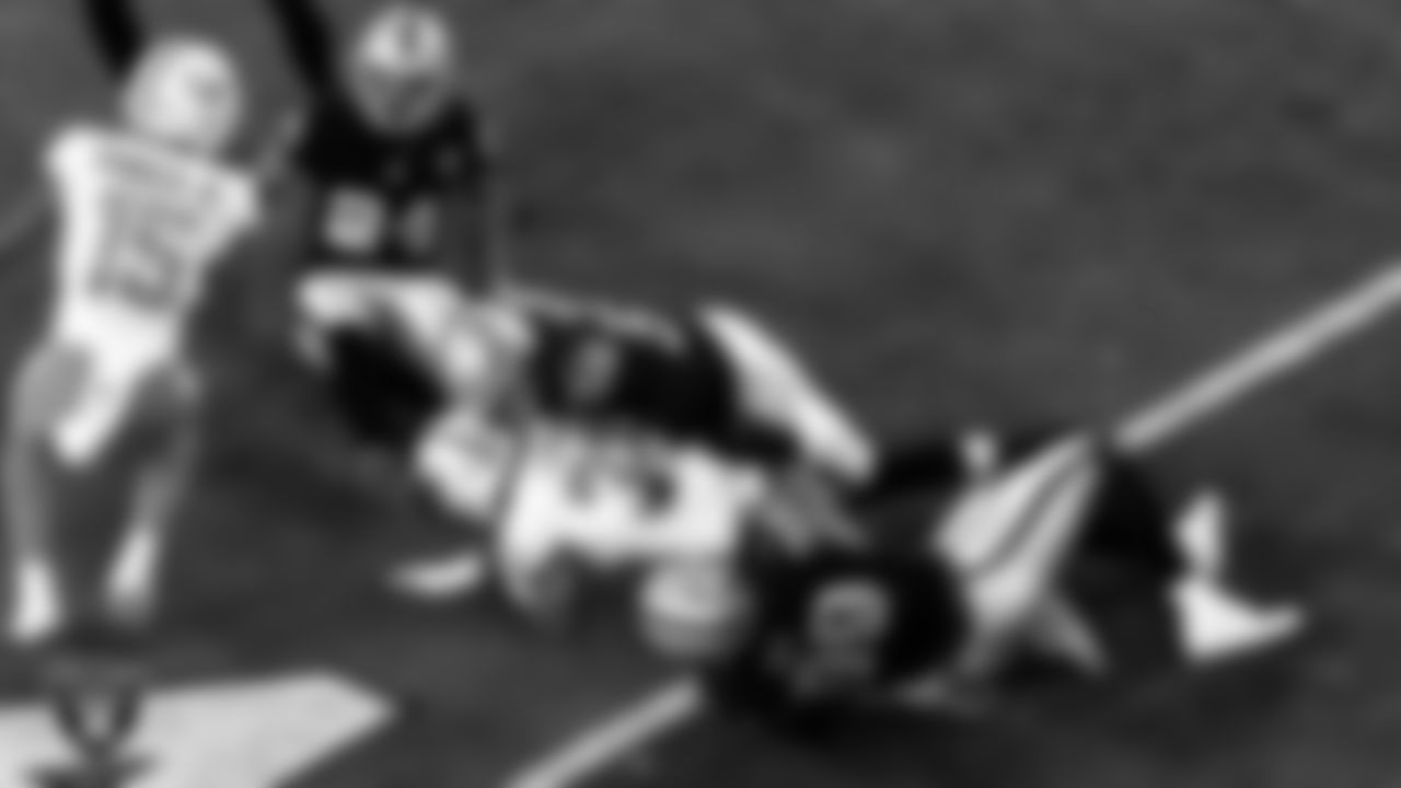 Las Vegas Raiders linebacker Kyle Wilber (58) and defensive end Arden Key (99) make a tackle during the regular season home game against the Miami Dolphins.