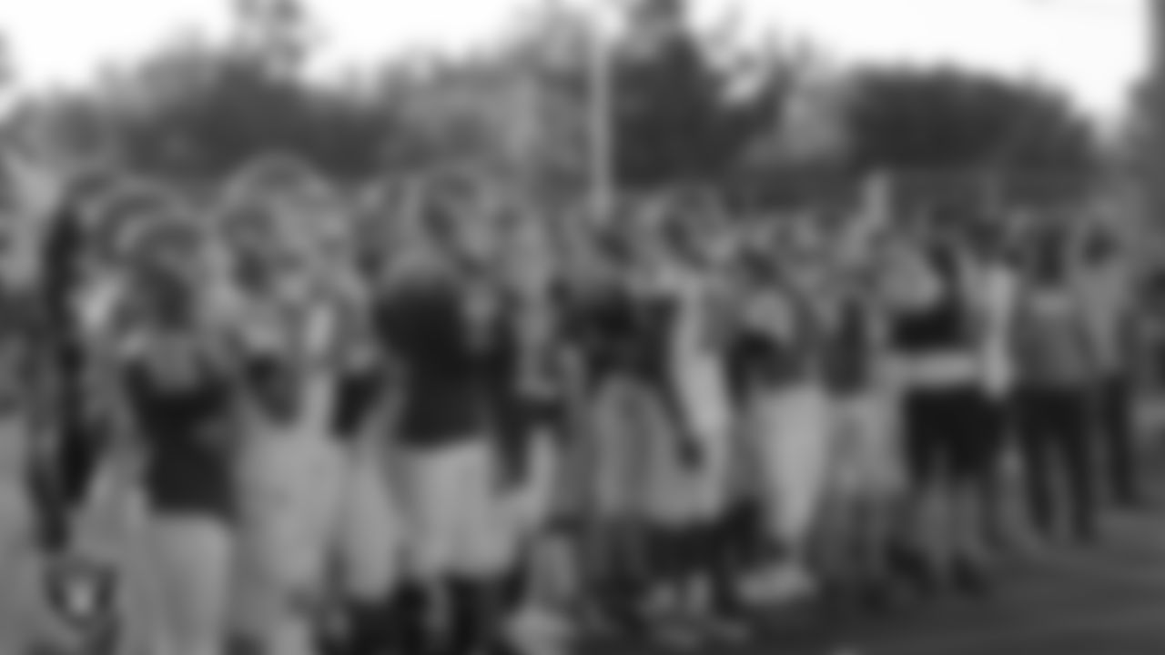 The Rancho High School football team listens to speakers during the ribbon cutting of the school's new synthetic field.