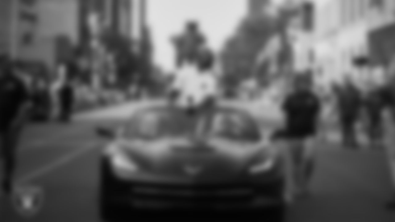 Hall of Famer Charles Woodson rides in the back of a convertible during the Canton Repository Grand Parade.