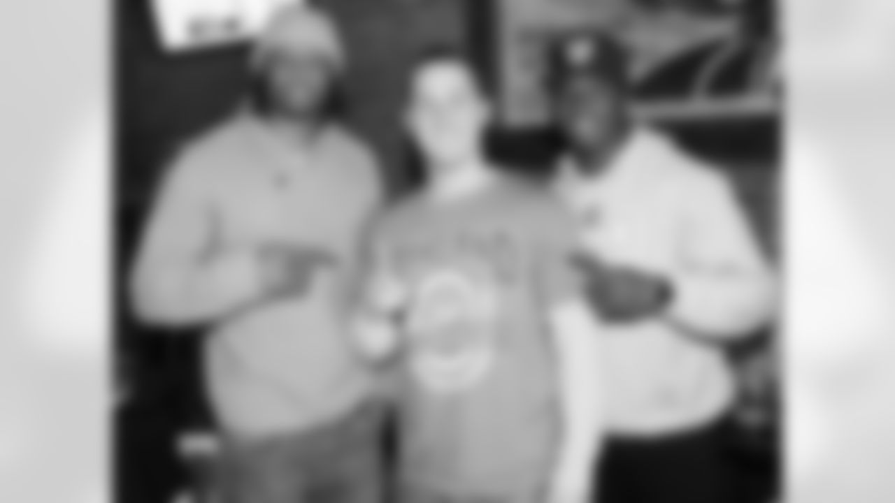 RB Taiwan Jones and WR Jacoby Ford pose for a photo with a fan.