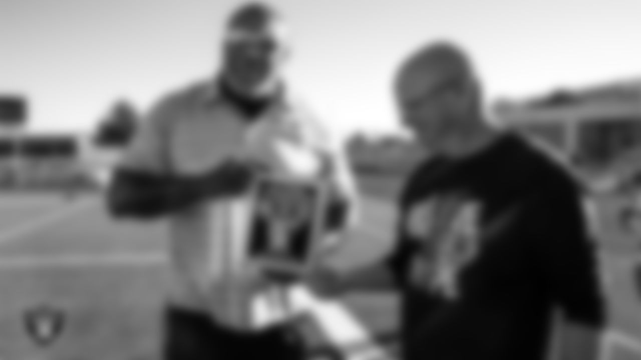 Las Vegas Raiders alumnus Roy Hart presents Chaparral High School's football coach Don Willis with the Tom Flores High School Coach of the Week award.