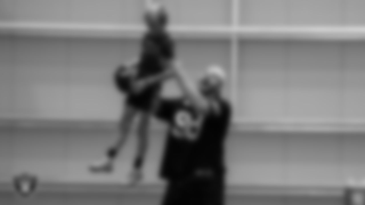Las Vegas Raiders defensive end Maxx Crosby (98) lifts a participant in the air after they made a catch during the Raiders Skills Camp.