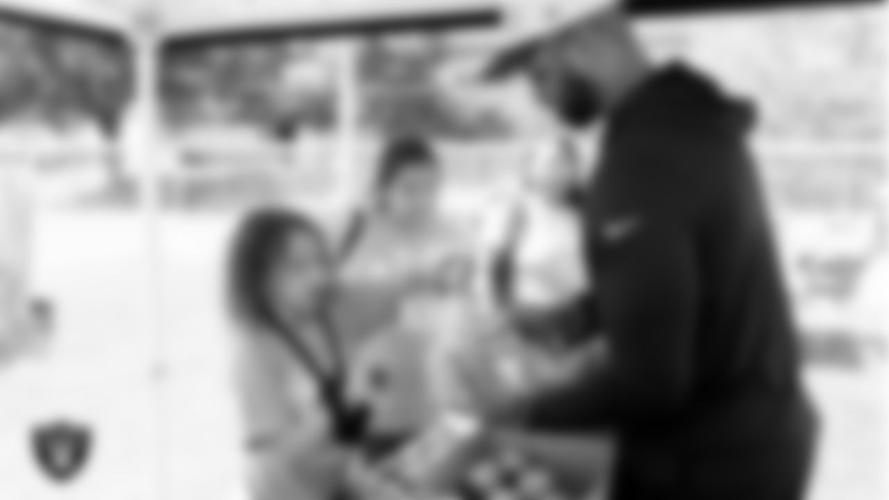 Las Vegas Raiders manager of community relations Jibri Blount hands out fresh produce from Melissa's Produce to community members at the Raiders' Stretch and Move station during the annual Kids Day Out at Lied Memorial Clubhouse.
