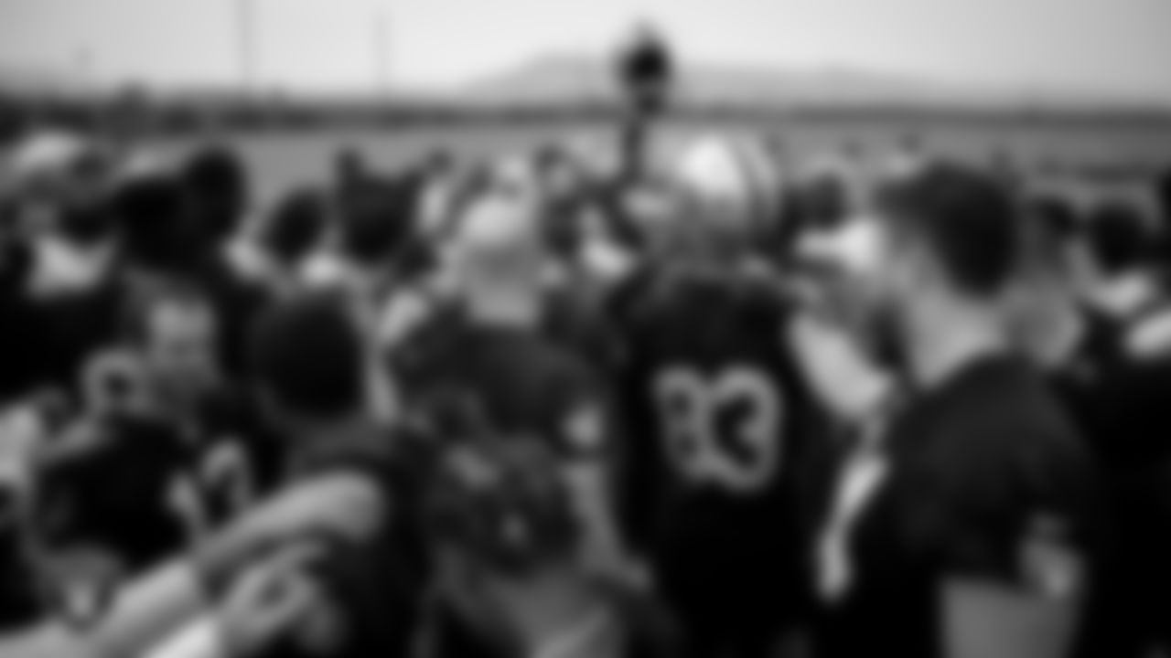 Las Vegas Raiders players and coaches huddle during practice.