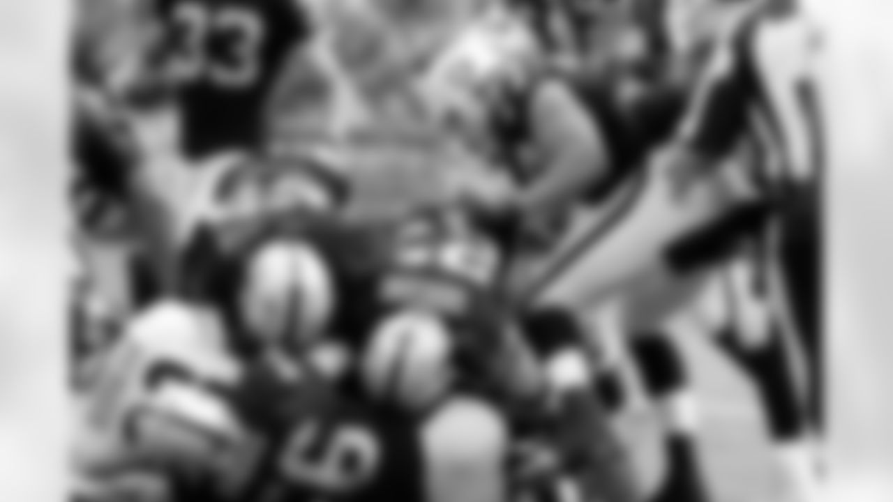 The Raiders swarm tackle the ball carrier.