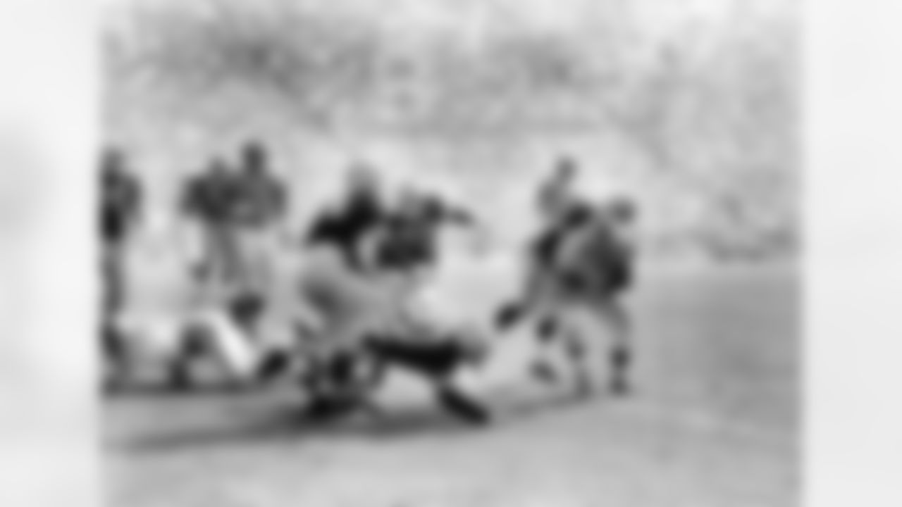 Game action between the L.A. Rams and the Pittsburgh Steelers at Los Angeles, Oct. 2, 1955. Identifiable players are: Rams' Duane Putnam (61) and Norm van Brocklin (11), and Steelers' Ernie Stautner (70) and John Reger (50). (Vic Stein via AP)