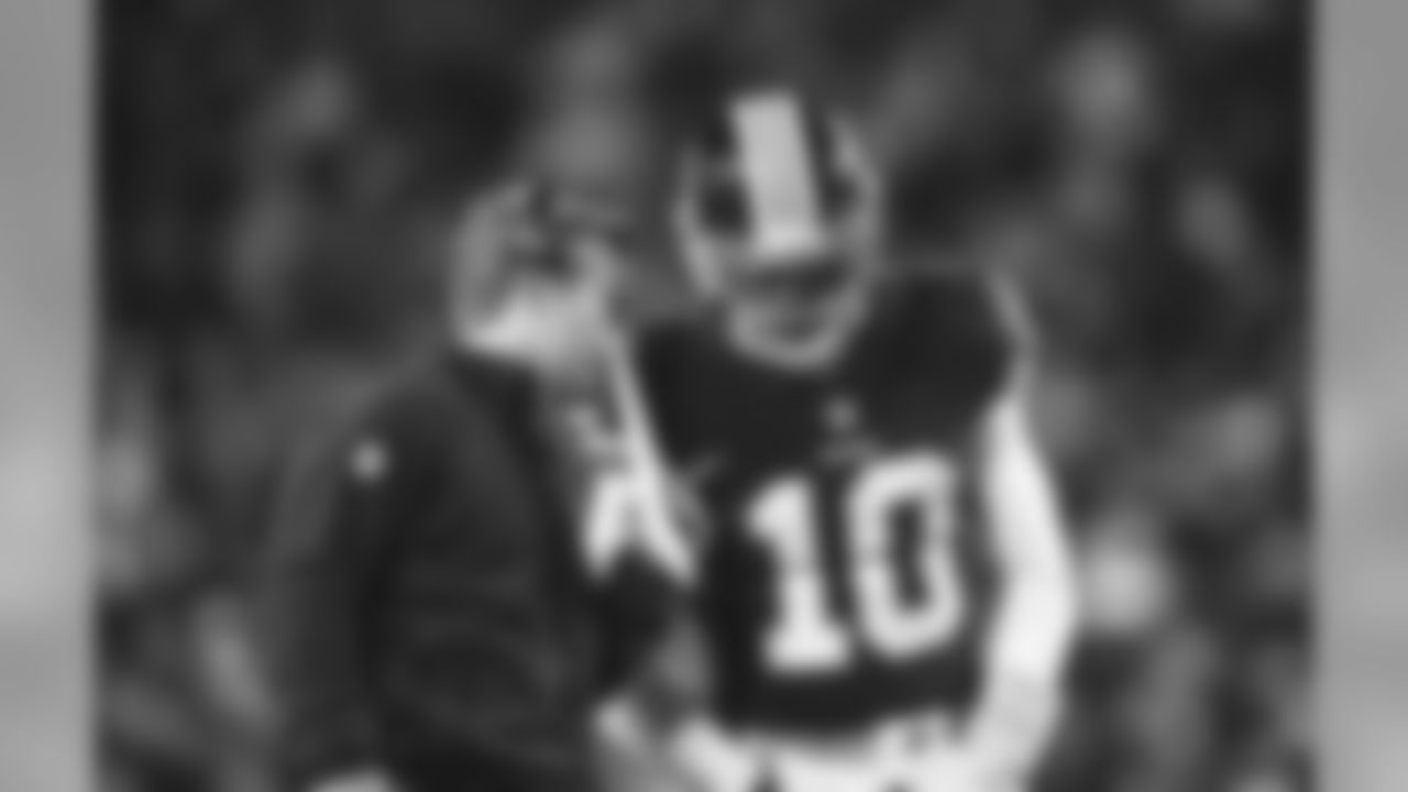 Washington Redskins offensive coordinator Sean McVay speaks with quarterback Robert Griffin III (10) during an NFL football game against the Philadelphia Eagles at FedEx Field on Saturday, December 20, 2014 in Landover, Maryland. Washington won 27-24. (AP Photo/Aaron M. Sprecher)