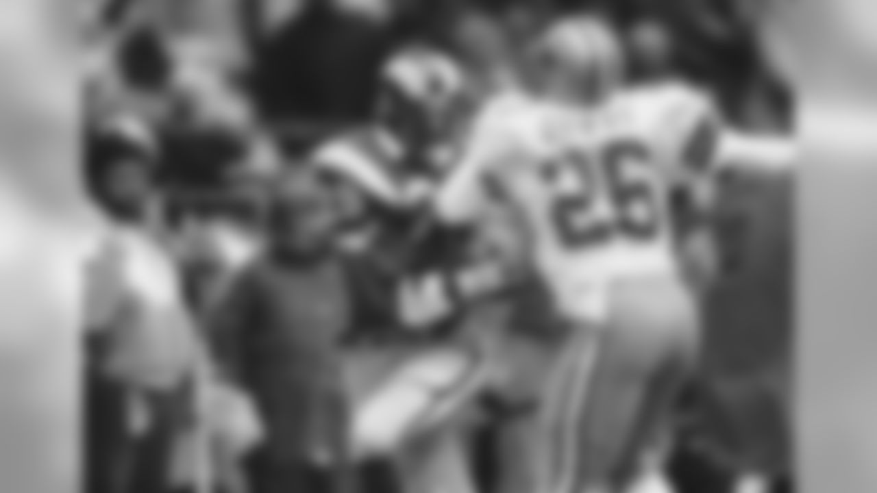 Los Angeles Rams halfback Eric Dickerson, left, carriers into Dallas Cowboys safety Michael Downs, right, as he moves the ball for yardage during third quarter action in Irving, Texas on Monday, Dec. 26, 1983. The Rams won it 24-17 to take the NFL wild card game. (AP Photo/Bill Haber)