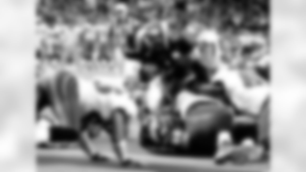 St. Louis Rams running back Marshall Faulk (28) holds on to the football while diving between the Tampa Bay Buccaneers defense to score in the second quarter of their game in St. Louis Monday, Oct. 18, 2004. (AP Photo/James A. Finley)