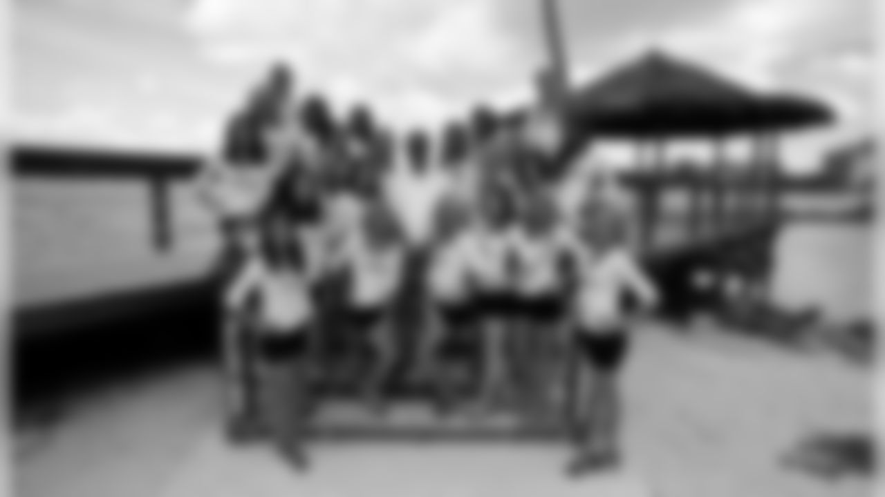 The cheerleaders pose with Bahamas Film Commissioner Craig Woods. (Photo by Rob Bartlett)