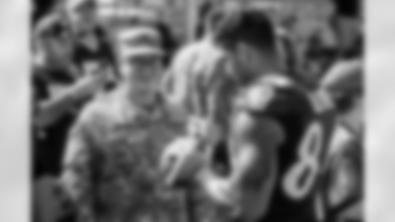 TE Josh Oliver autographs a fan's football.