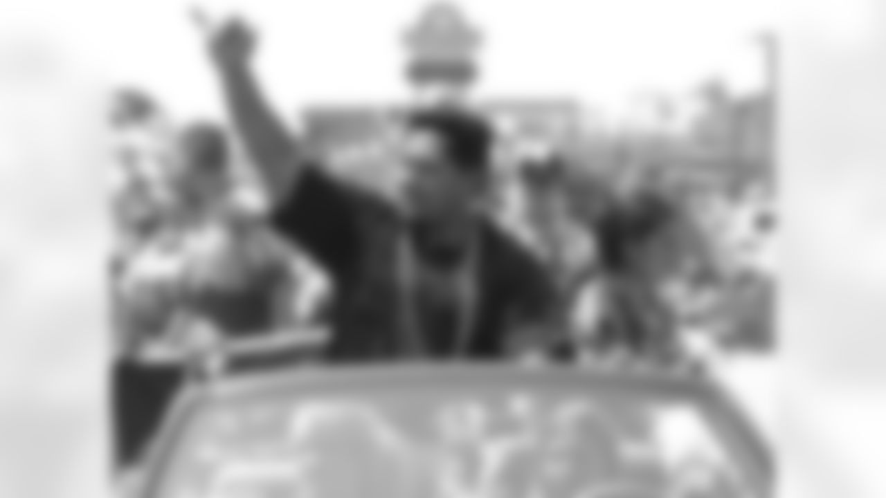 Former Raven Edwin Mulitalo waves to fans during the parade.