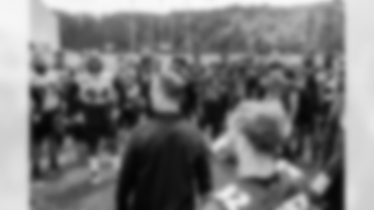 The team listens to Head Coach John Harbaugh after practice