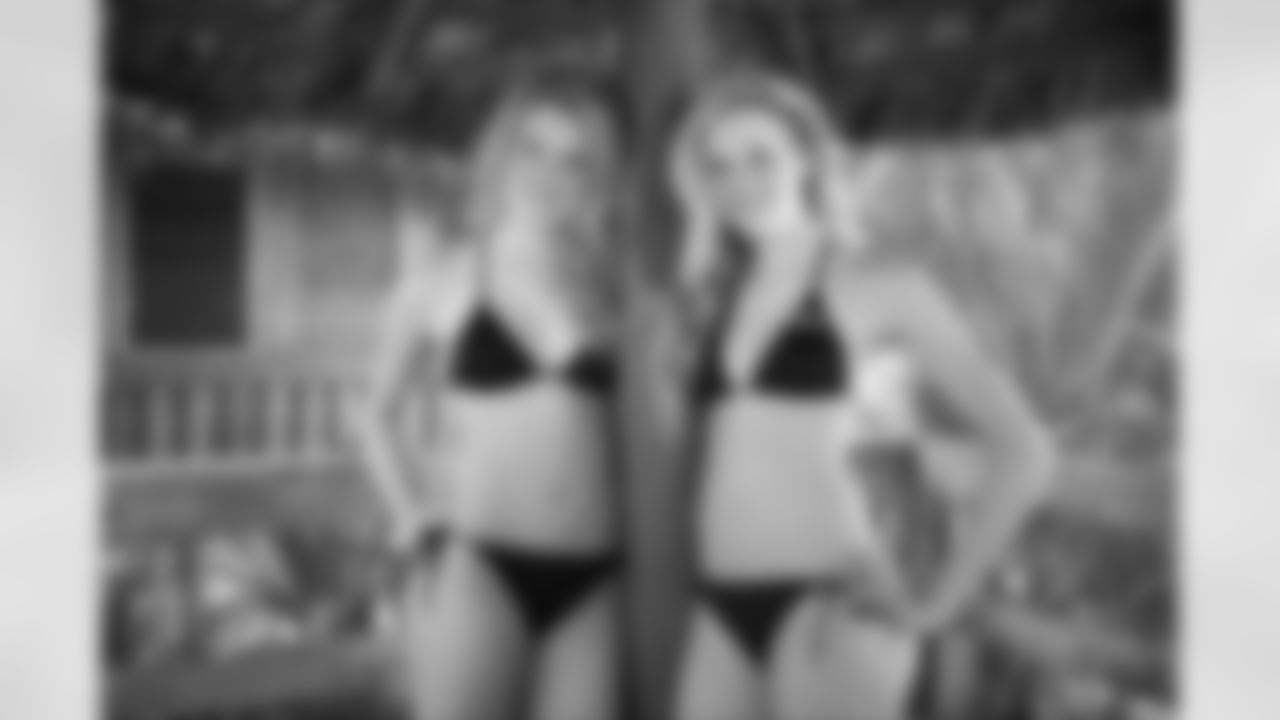 Twin sisters Chase and Paige pose together under a grass hut for their calendar shoot.