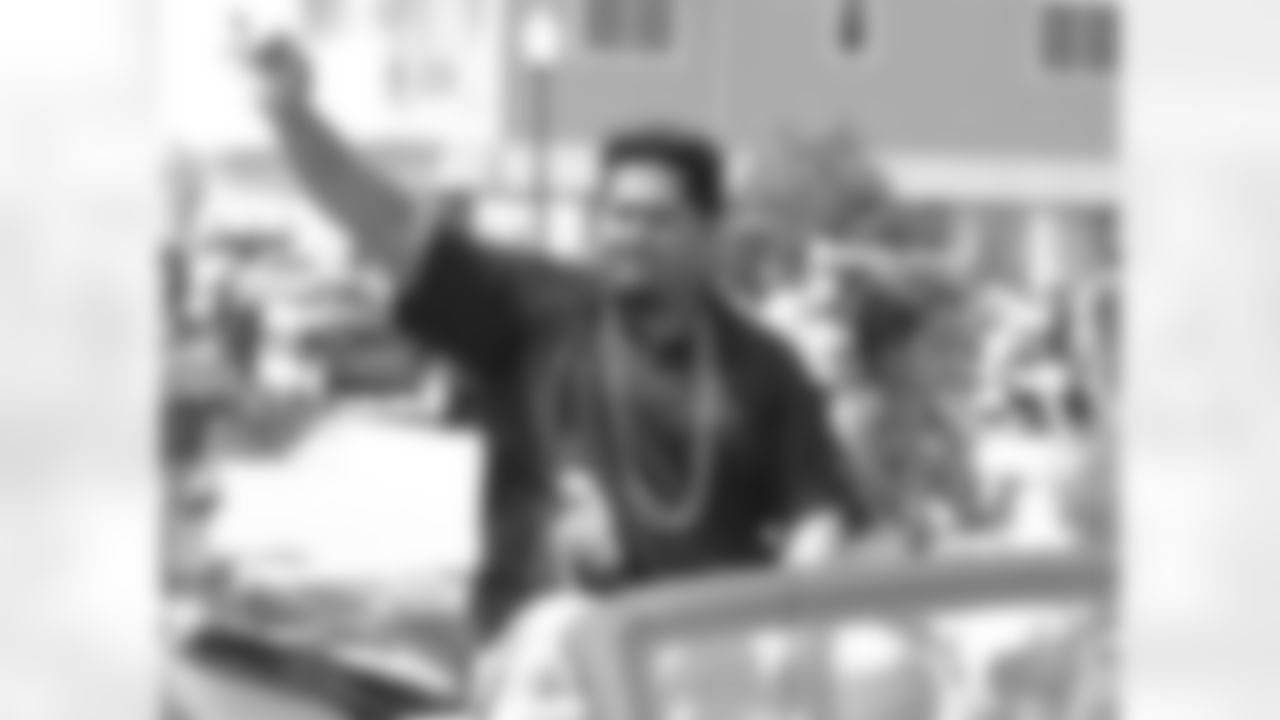 Former Raven Edwin Mulitalo waves to fans during the parade.