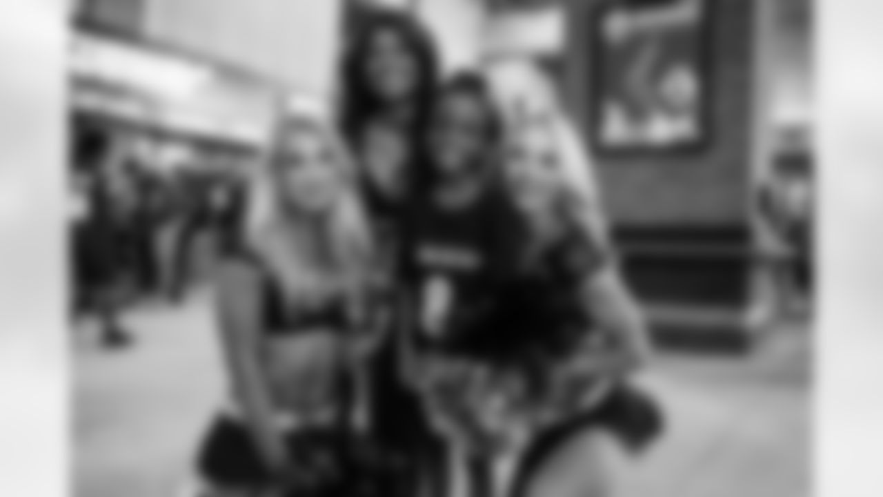 Ravens cheerleaders pose with a young fan.