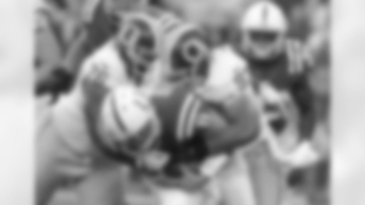 Redskins LB Lorenzo Alexander and DE Darrion Scott tackle Colts QB Chandler Harnish during the Redskins-Colts game.