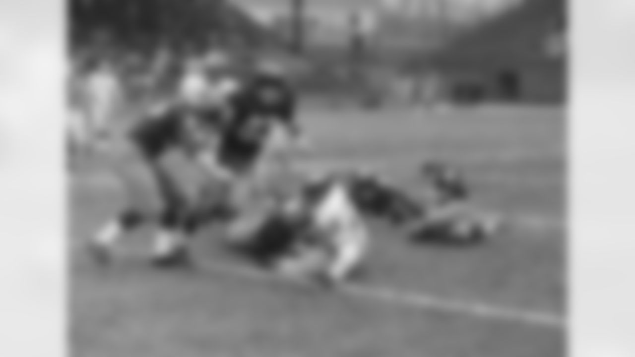 Philadelphia Eagles fullback Clarence Peaks (26) is brought down by Washington Redskin tackle Will Renfro (71) after a six-yard first quarter running gain at Griffith Stadium, Dec. 6, 1959, Washington, D.C. Swarming in on Peaks is fullback Chuck Drazenovich (36) and end Ed Meadows (83), both of Washington. In the background is Chuck Bednarik (60), Eagles center. (AP Photo/Tom Fitzsimmons)