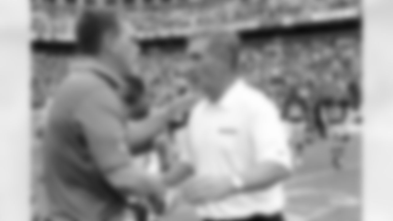 Head coach Mike Shanahan and Lions head coach Jim Schwartz shake hands after the game.