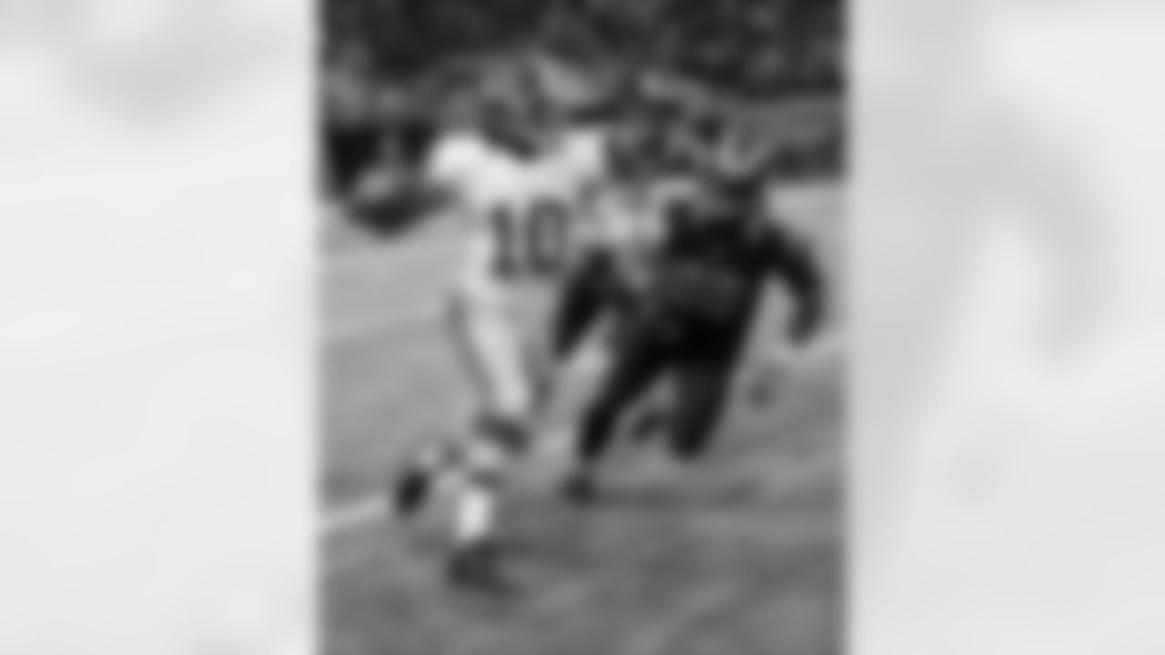 Redskins QB Robert Griffin III throws a pass as he scrambles in the Redskins-Rams game.