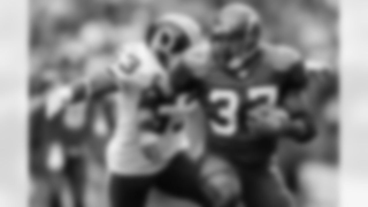Marcus Washington tackles Shaun Alexander from behind.