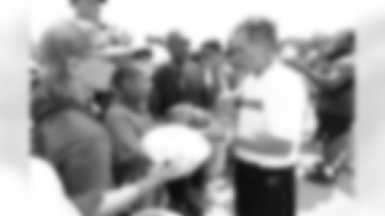 Redskins Head Coach Mike Shanahan signs autographs for fans on Fan Appreciation Day.
