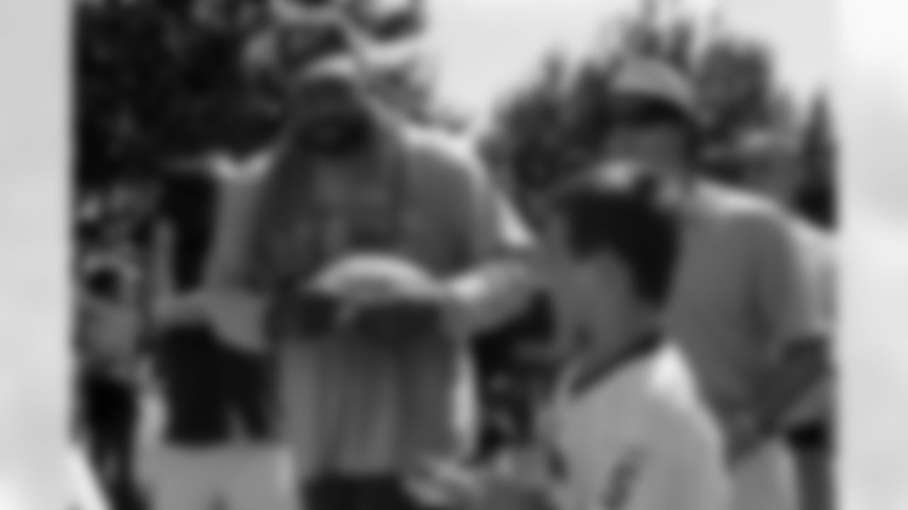 Albert Haynewsworth signing a football for a fan (AP Photo)