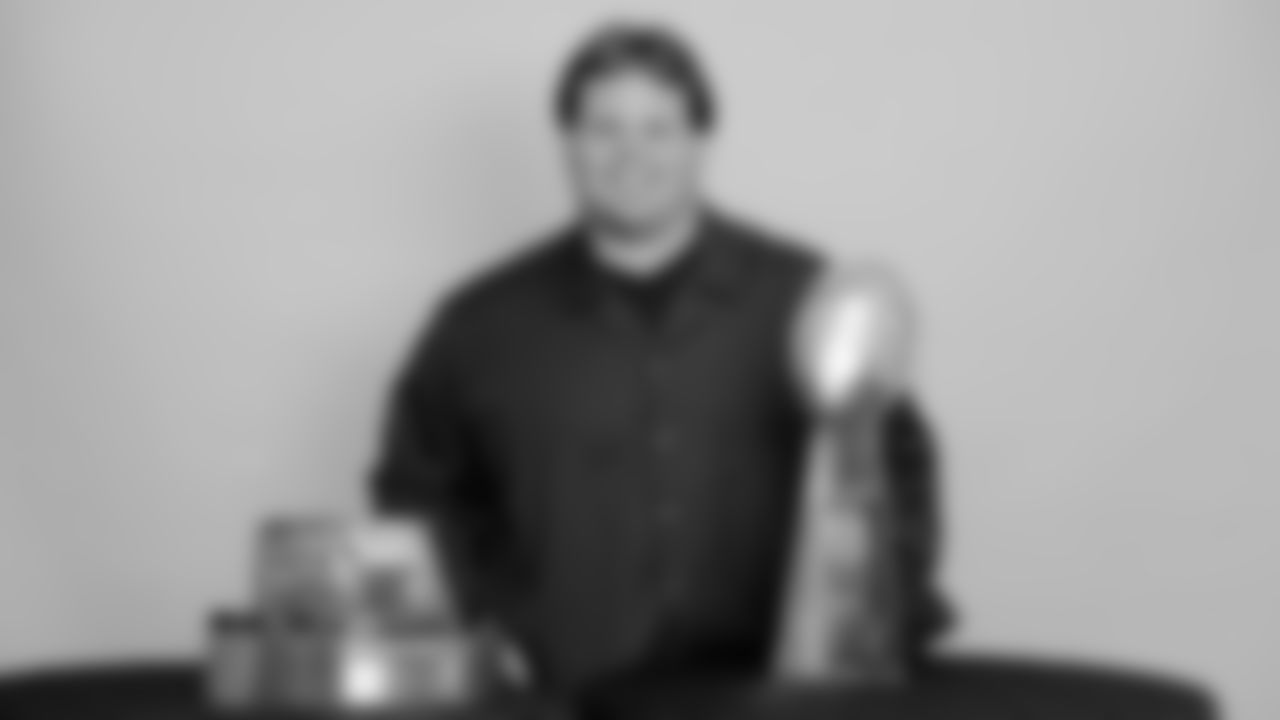 New Orleans Saints defensive tackle Rodney Leisle poses with the XLIV Super Bowl trophy in 2010.