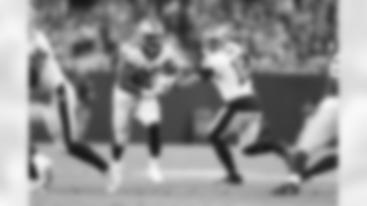 New Orleans Saints running back Devine Ozigbo (28) and quarterback Ian Book (16) in action during their 2022 Preseason Week 2 game against the Green Bay Packers.