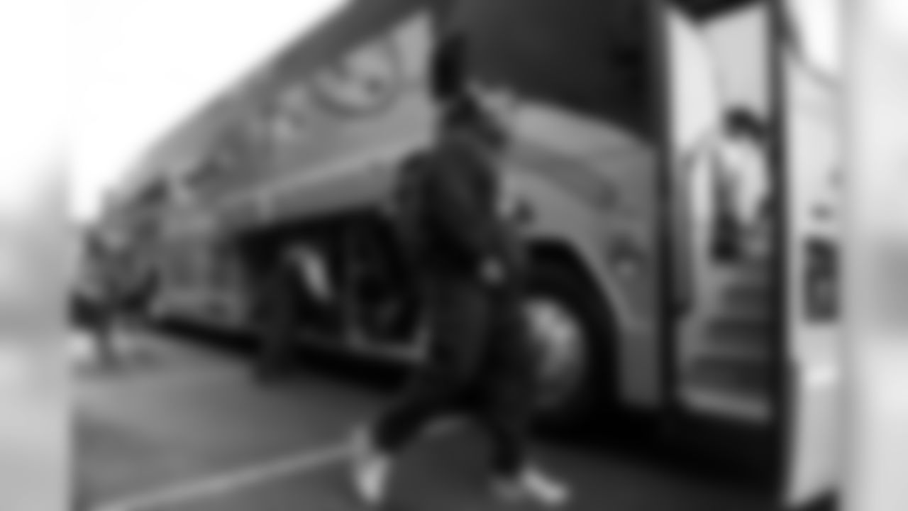 Seahawks running back Marshawn Lynch boards Bus #2 in his matching gold headphones and shoes.