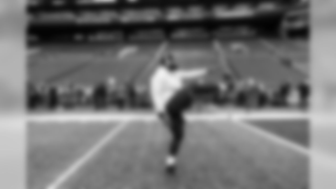 On the field, defensive lineman Shamar Stephen stretches during early pregame warmups.
