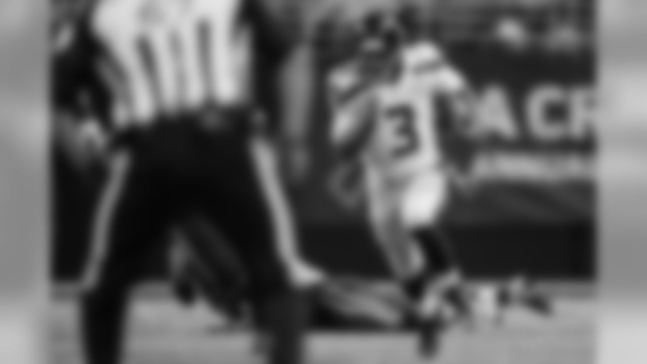 Russell Wilson leaves the Rams in his wake as he runs up the left side for a 52-yard gain. Wilson became the first player in N.F.L. history to pass for over 300 yards and rush for over 100 yards in a single game.