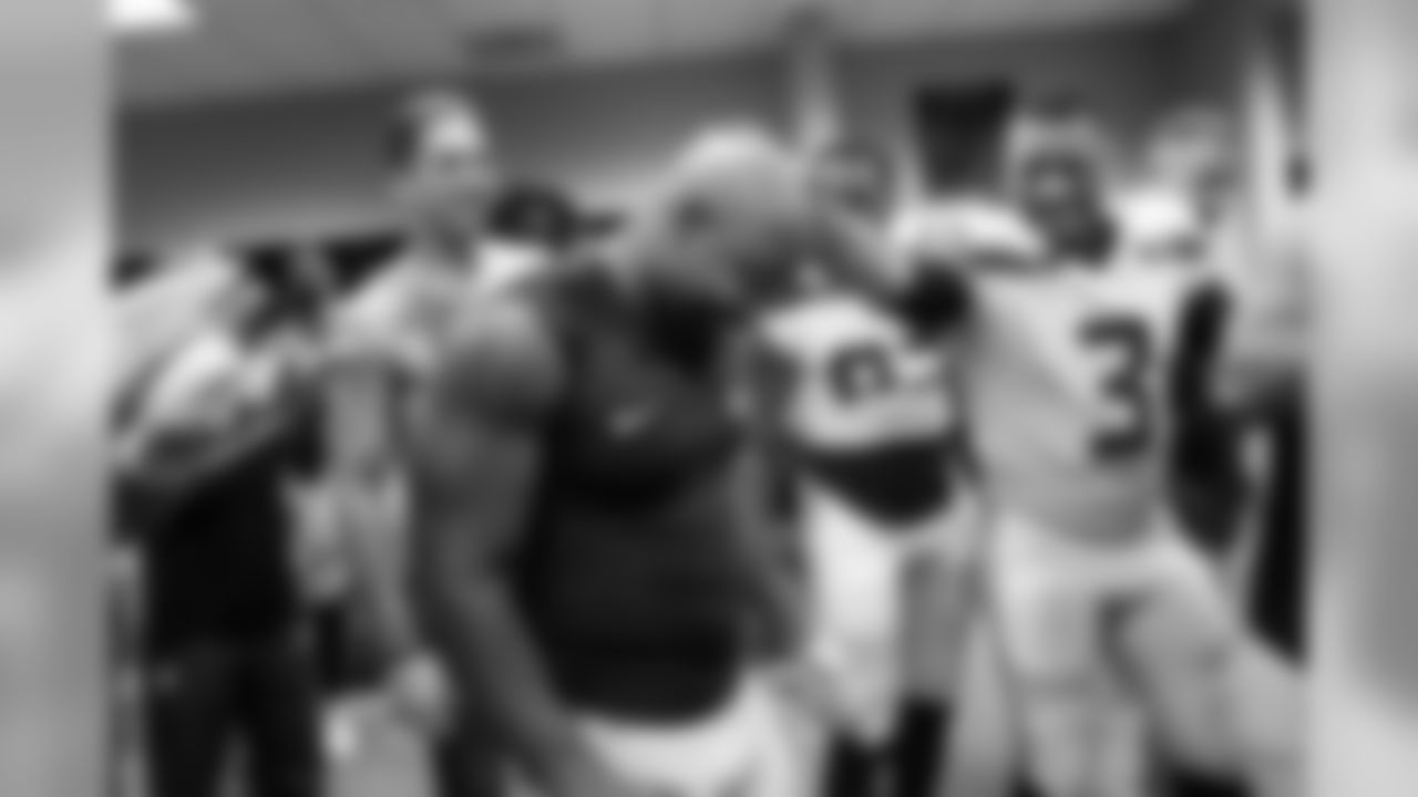 Running back Mike Davis, who rushed for 101 yards and two touchdowns, is celebrated by teammates including quarterback Russell Wilson in the locker room after the game.