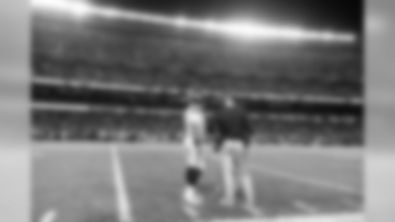 Quarterback Russell Wilson and offensive coordinator Brian Schottenheimer confer near the sidelines during a timeout.