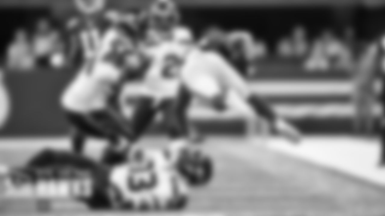 Seattle's Jamal Adams upends a Colts player as Rasheem Green apporches to finish the tackle.