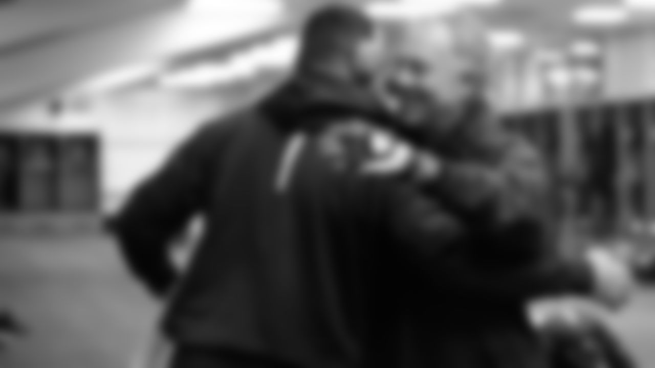 Quarterbacks coach Carl Smith gives a hug to Russell Wilson in the locker room.