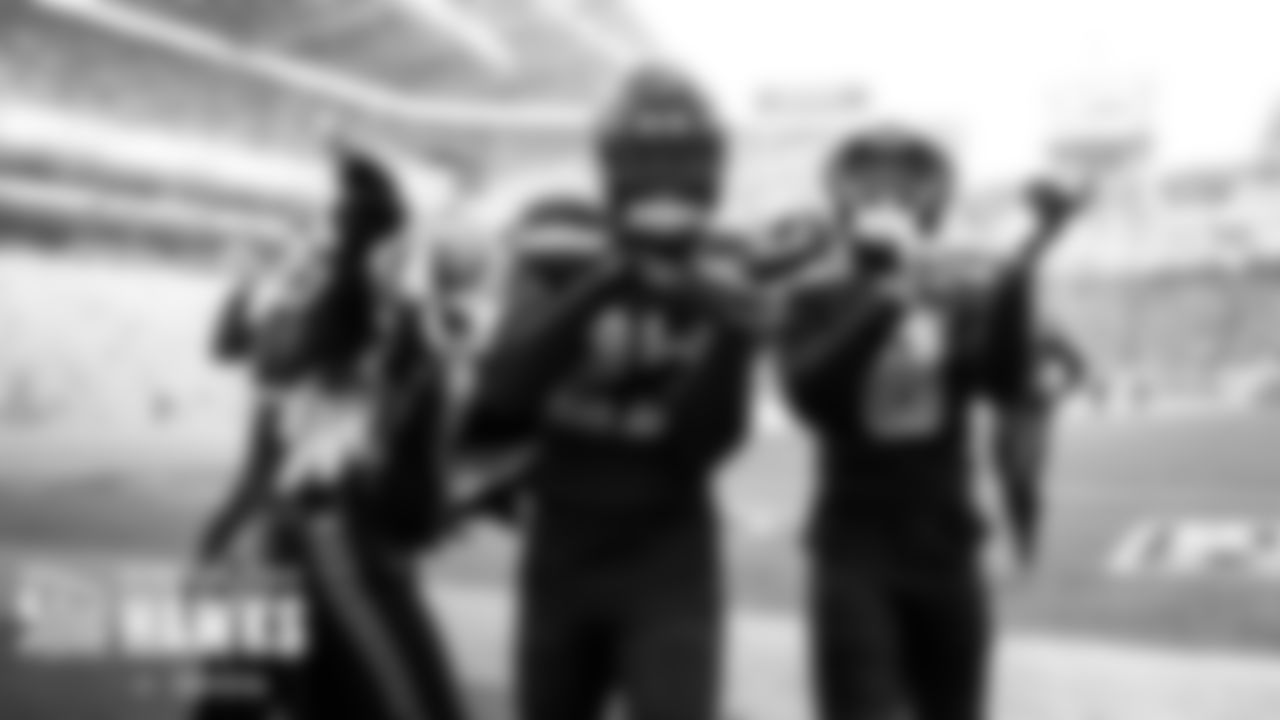 Defensive backs Tariq Woolen and Coby Bryant celebrate with Blitz after an interception.