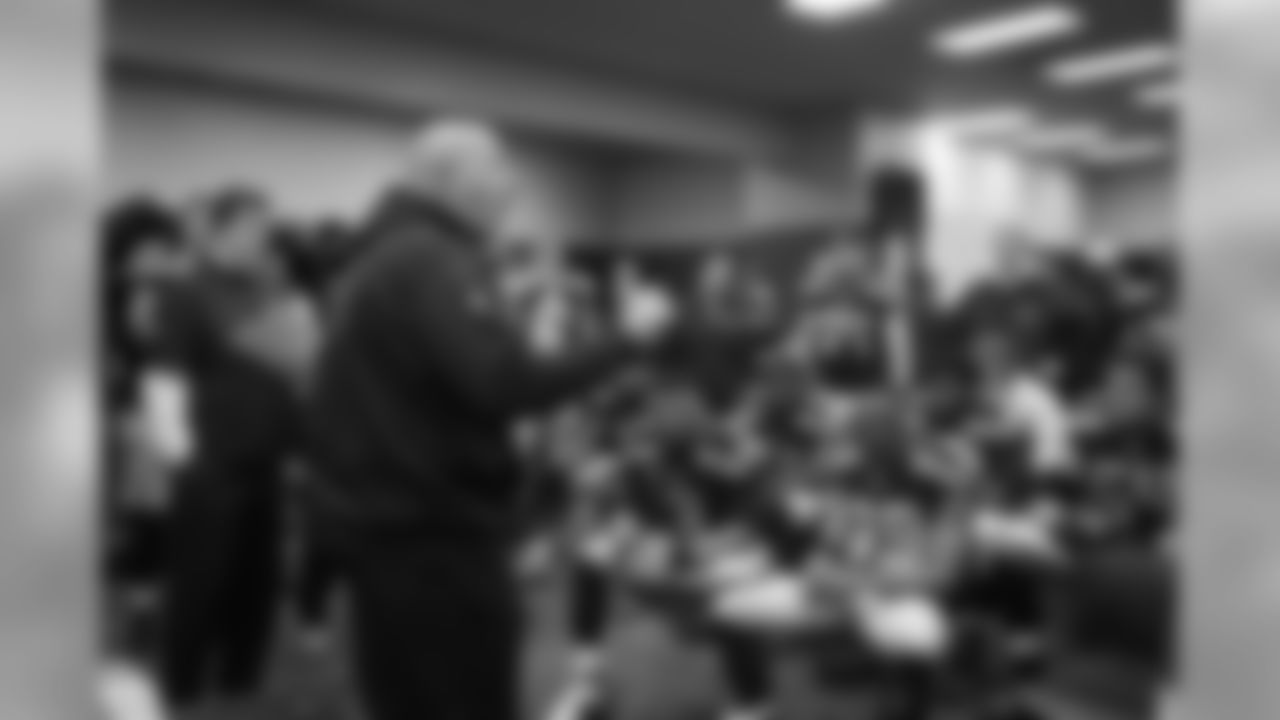 On the other side of the locker room, assistant head coach Tom Cable addresses the offense.