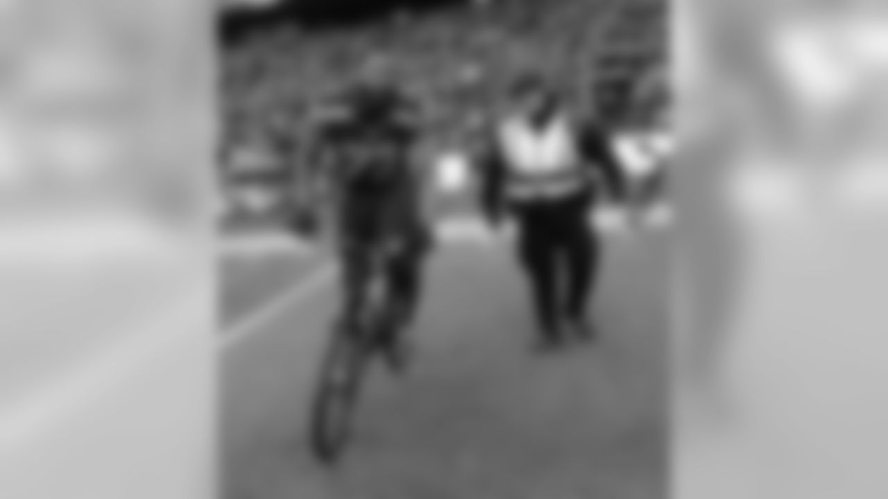 Seattle Seahawks' Michael Bennett borrows a police officers bike after overtime of the NFL football NFC Championship game against the Green Bay Packers Sunday, Jan. 18, 2015, in Seattle. The Seahawks won 28-22 to advance to Super Bowl XLIX. (AP Photo/David J. Phillip)
