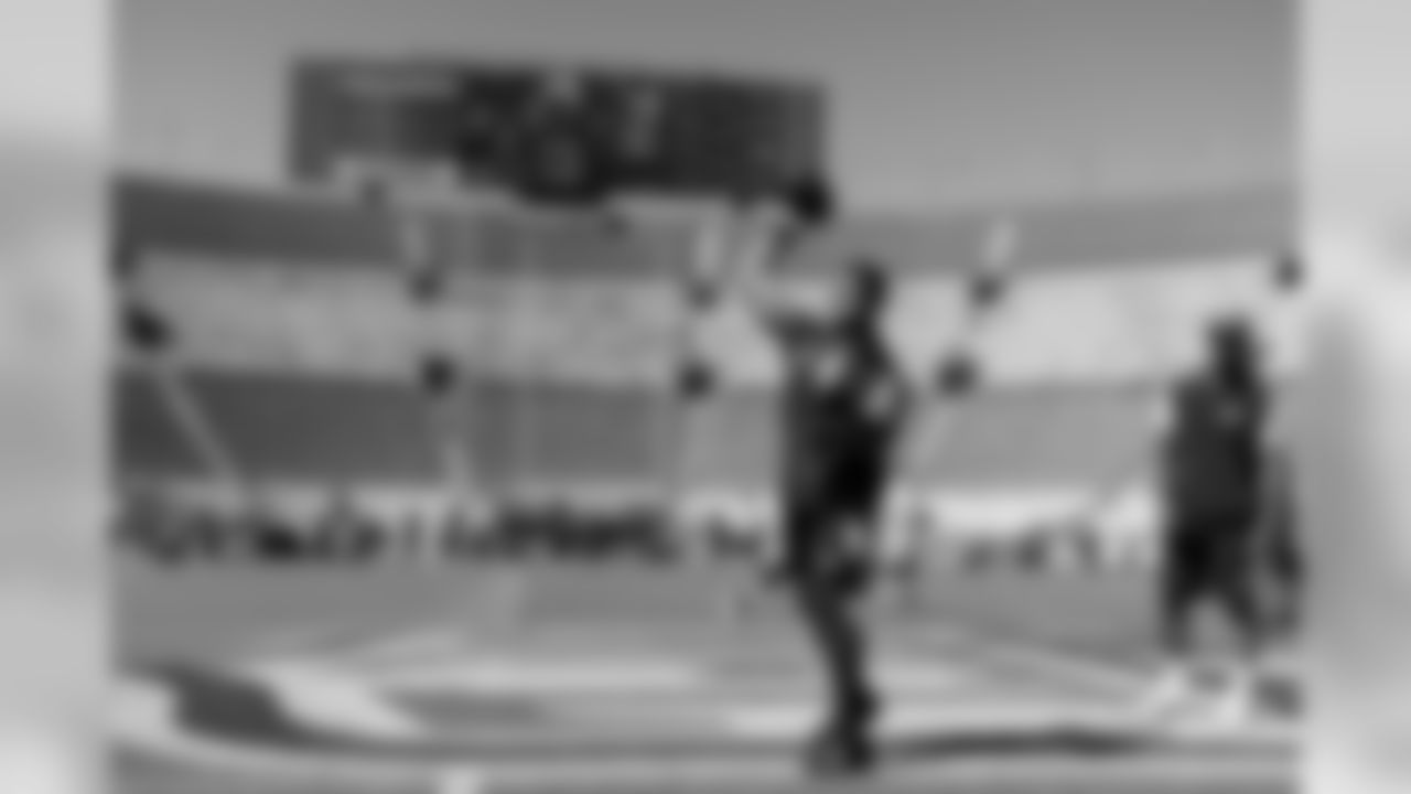 Quarterback Russell Wilson takes his early warmup throws on the NFL logo painted at midfield at Los Angeles Memorial Coliseum prior to facing the Rams.