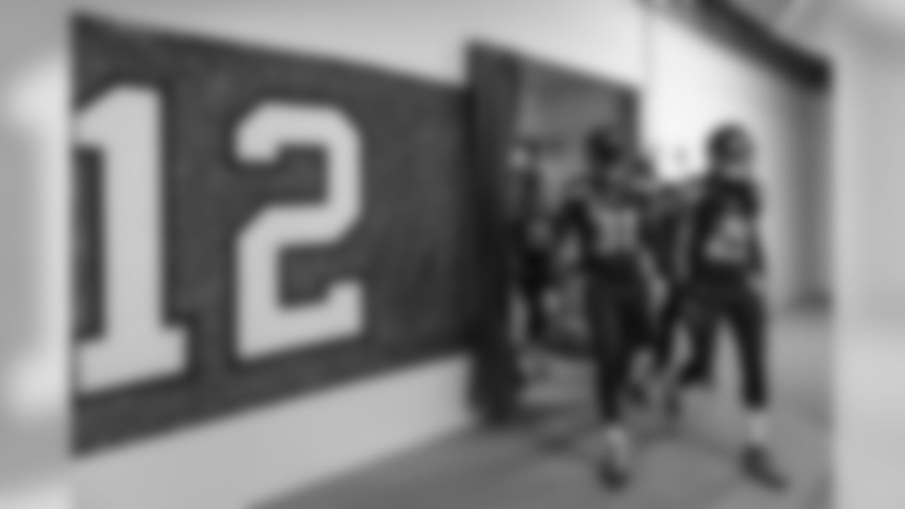 At 12:15, the defensive backs, led by Kam Chancellor and Richard Sherman, left the locker room an headed to the field, passing a large 12 flag signed by fans.